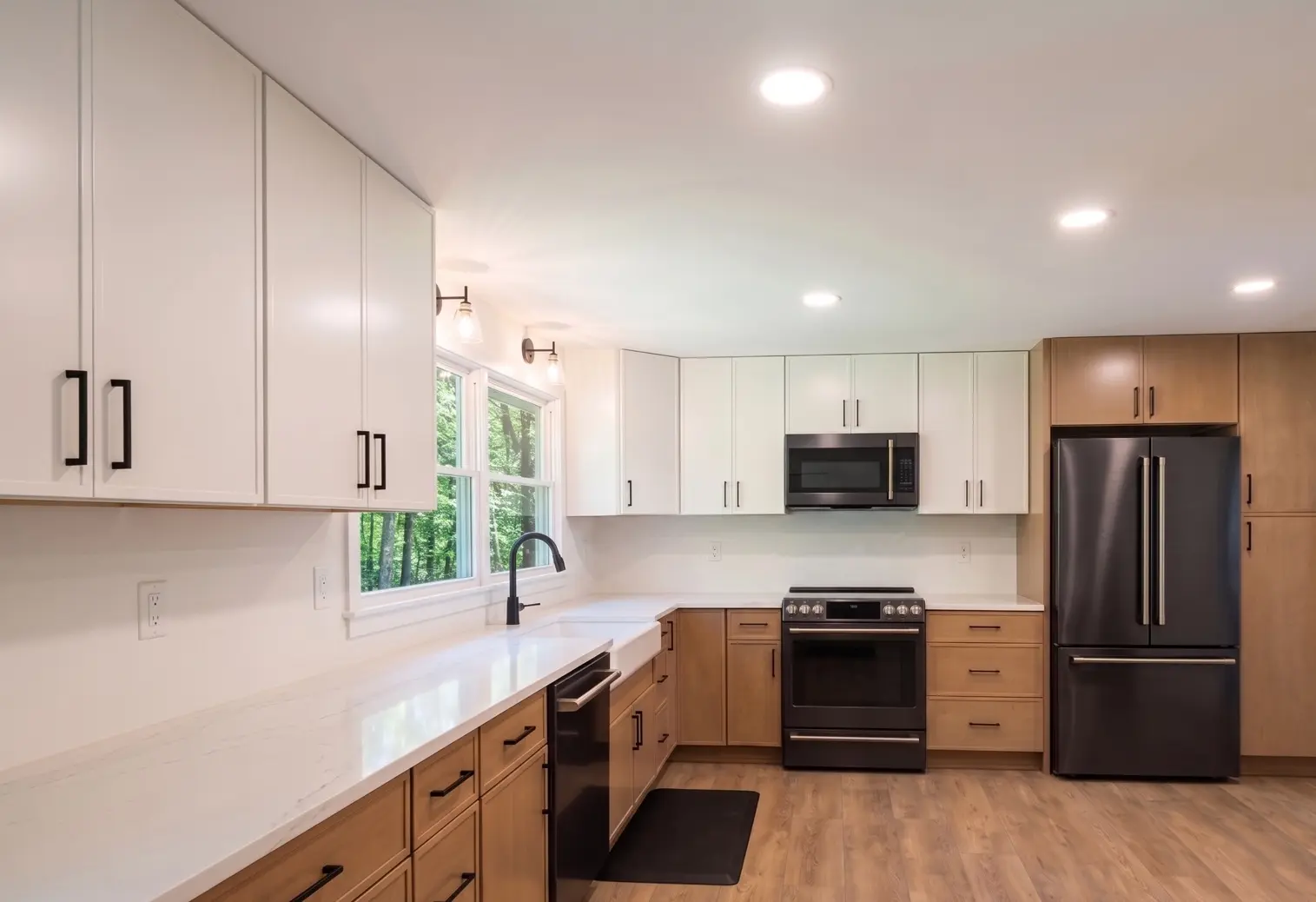 Renovated kitchen with white cabinetry and wood accents